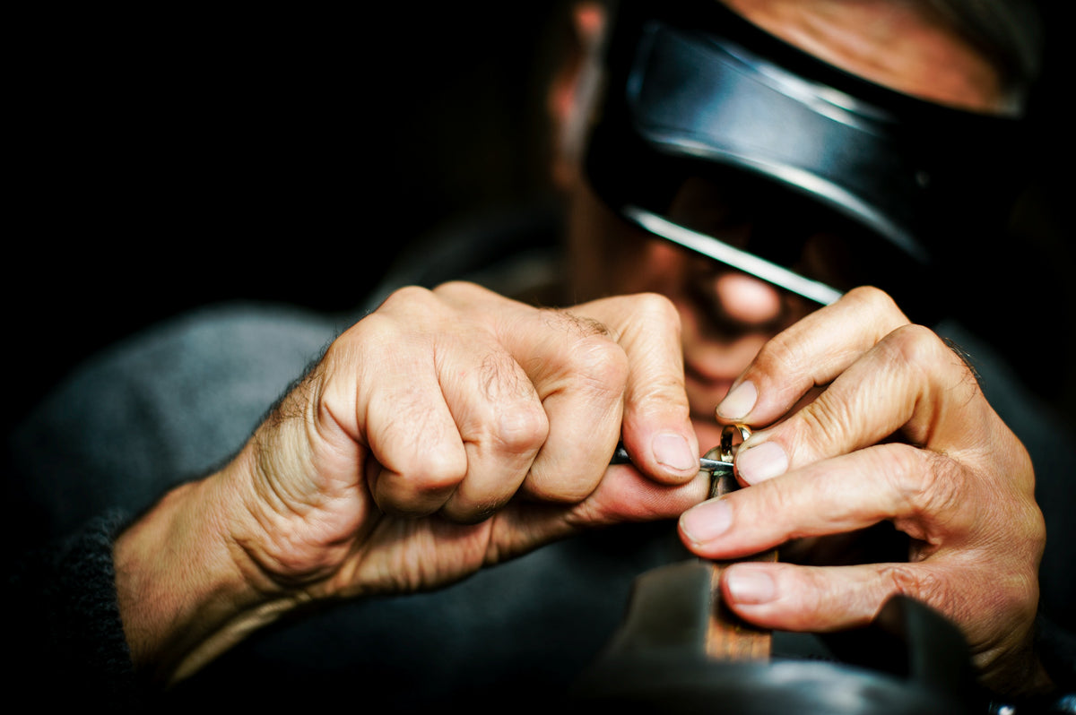 A jeweller inspecting a ring through a loupe