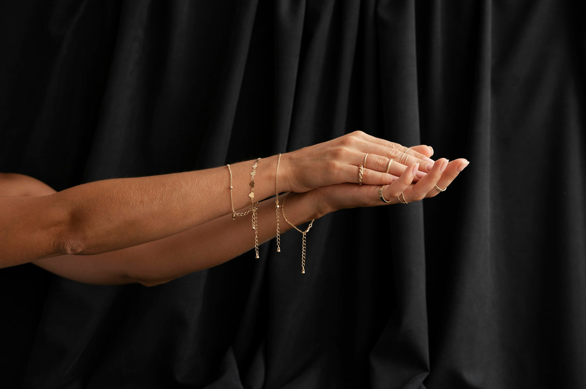Woman in a black dress holding a fine bracelet